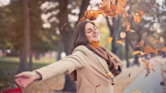 vrouw aan het gooien met herfstbladeren