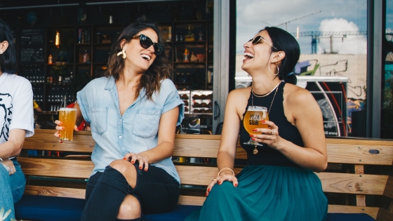 twee dames die een glaasje drinken in een café